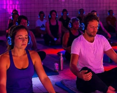 Deelnemers mediteren met koptelefoon tijdens The Energy Reset